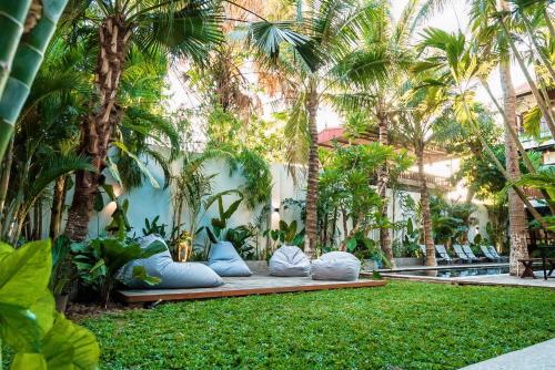 a garden with pillows and palm trees next to a pool at The Laneway Hostel in Xuân Sơn
