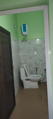 a bathroom with a toilet and a phone on the wall at Winter Valley Grand Araku in Araku