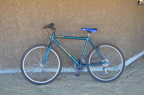 a blue bike parked next to a wall at Coyunche Cabañas y Camping Laja & San Rosendo in Laja