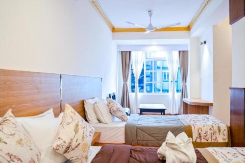 a hotel room with two beds and a window at Hotel The Dzong ! Gangtok in Gangtok