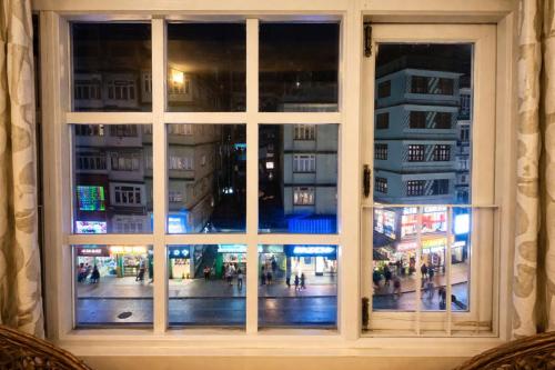 a window with a view of a city at night at Hotel The Dzong ! Gangtok in Gangtok