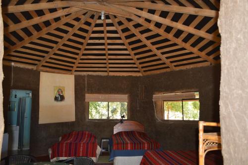 a room with a large wooden ceiling with windows at Coyunche Cabañas y Camping Laja & San Rosendo in Laja