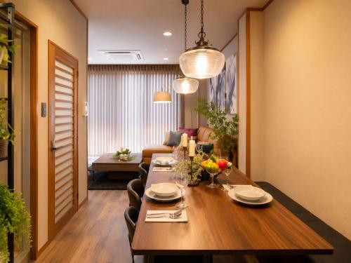 a dining room with a table and a couch at simasima-stay高松駅 ー 高松駅徒歩2分 無料駐車場ー in Takamatsu