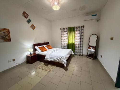 a bedroom with a bed in a room with a window at My stay in Yaoundé