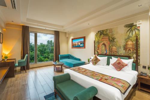 a hotel room with a large bed and a couch at Tripli Regalia Mayur Palace in Udaipur