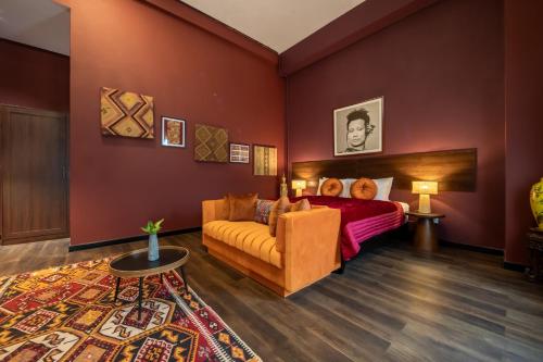 a bedroom with red walls and a couch and a bed at Inpeng View Hotel in Vientiane