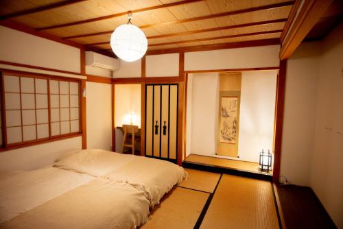 a bedroom with a bed in a room with a ceiling at Nomachi Villa in Kanazawa