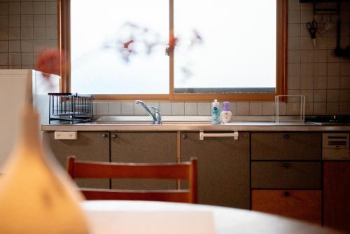 a kitchen with a sink and a table and a window at Nomachi Villa in Kanazawa