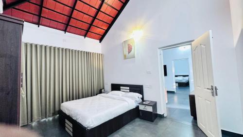a bedroom with a bed and a large window at Royal Heaven Wayanad in Ambalavayal