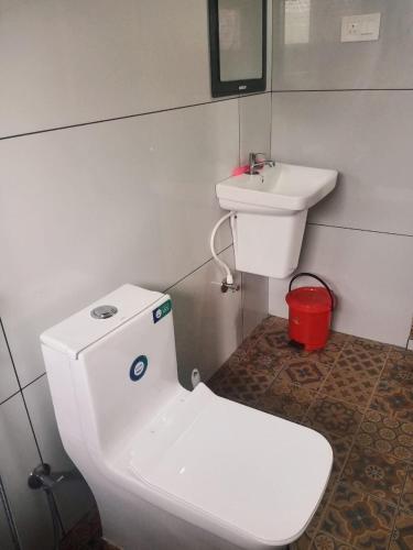 a bathroom with a white toilet and a sink at Royal Heaven Wayanad in Ambalavayal