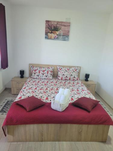 a bedroom with a bed with a red blanket and pillows at Casa Corina in Turda