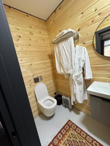 a wooden bathroom with a toilet and a sink at Zarechnoe Guest House in Tash-Tyube