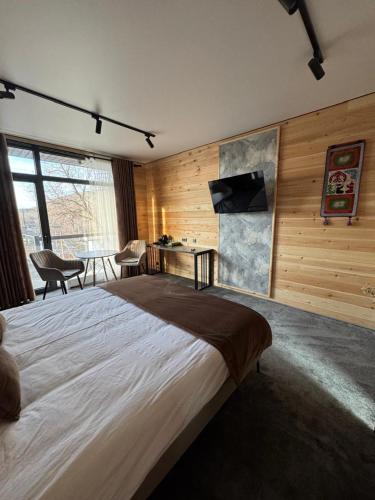 a large bedroom with a large bed and a table at Zarechnoe Guest House in Tash-Tyube