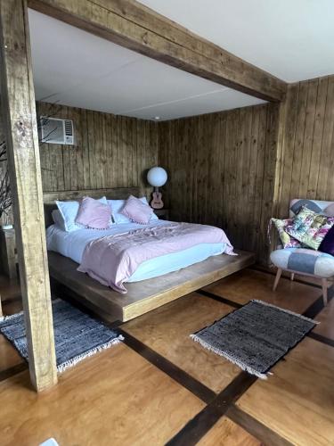 a bedroom with a bed and a chair at Cabaña in Pirque