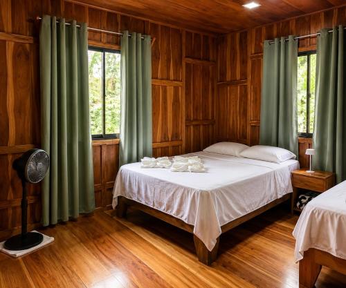 a bedroom with a large bed with green curtains at House Rio Celeste Paradise in Rio Celeste