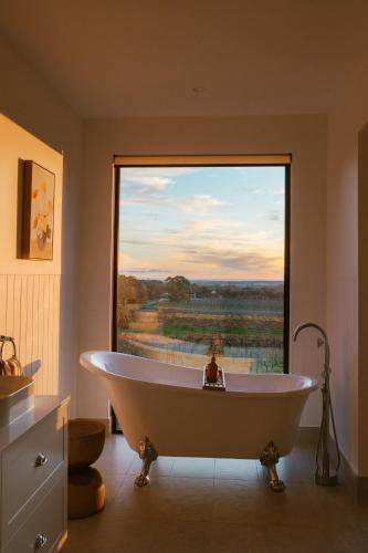 a bath tub in a bathroom with a large window at Monapilla Escape in McLaren Vale