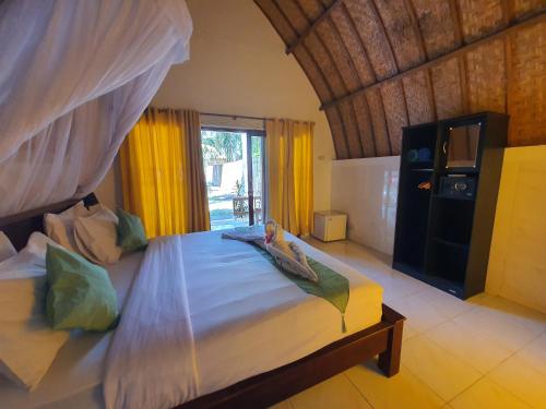 a bedroom with a bed with a canopy at G Two Cottages in Gili Islands