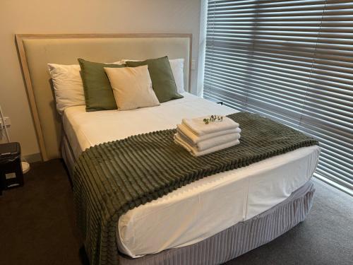 a bed with towels on it in a bedroom at Med-Accom in Sydney