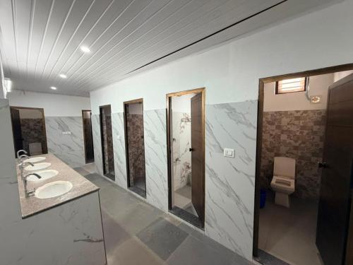 a bathroom with a row of sinks and mirrors at ABS Residency, Wayanad- Sulthan Bathery in Sultan Bathery