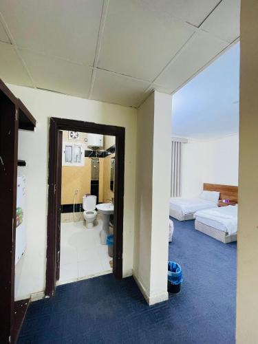 a room with two beds and a bathroom with a toilet at فندق دار العوالي3 in Medina