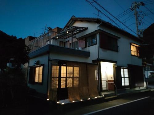 a house with lights on the side of it at night at Numazu Sparkle in Numazu