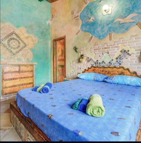 a bedroom with a large bed with blue sheets at Casa Gaudi - House & Rooms in Teulada