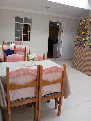a dining room with a table and chairs and a room with at Abril Hostel in Mollepata