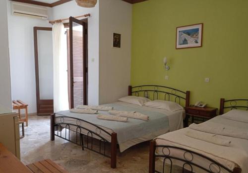 two beds in a room with green walls at samos town hostel in Samos