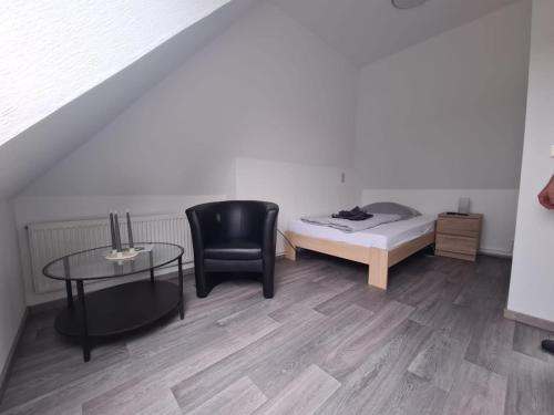 a room with a bed and a chair and a table at Hotel-Pension Friesenruh in Bensersiel