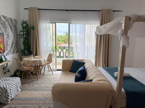 a bedroom with a bed and a bed and a couch at SeaEsta studio Shanzu Serena in Mombasa