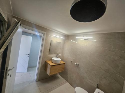 a bathroom with a sink and a toilet and a mirror at באוירה יהודית in H̱azon