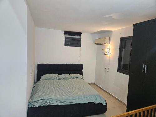 a small bedroom with a bed in the corner at באוירה יהודית in H̱azon