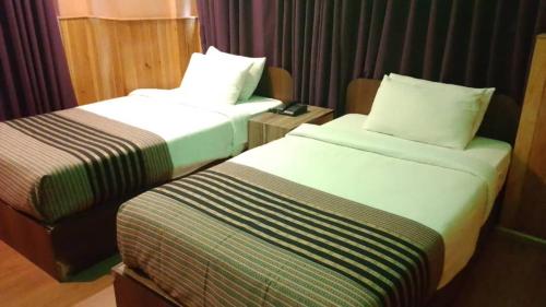 a hotel room with two beds and a table at Diamond Hotel in Kagha