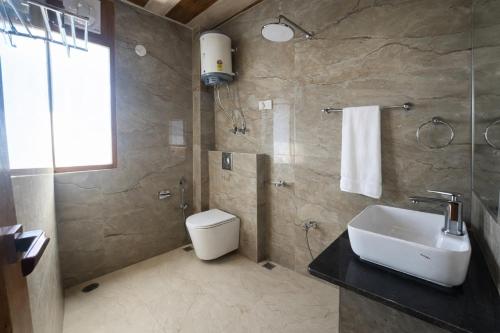 a bathroom with a sink and a toilet at LN Grand Premium & Luxury Suites, Manali in Manāli