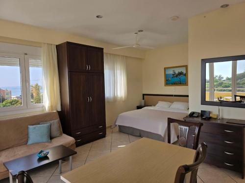 a hotel room with a bed and a couch at Yolanda Studios in Paralia Agias Foteinis