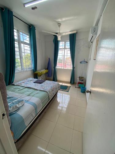 a bedroom with a bed with blue curtains and a door at DRIFF Homestay 3bedroom with aircond 50m to Night Market Wakaf Che Yeh in Kota Bharu