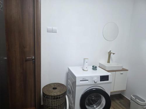 a washing machine in a bathroom with a sink at Studio Aurora Blue in Eforie Sud