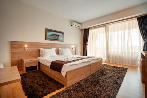 a bedroom with a large bed and a large window at Park Lakeside Ohrid in Ohrid