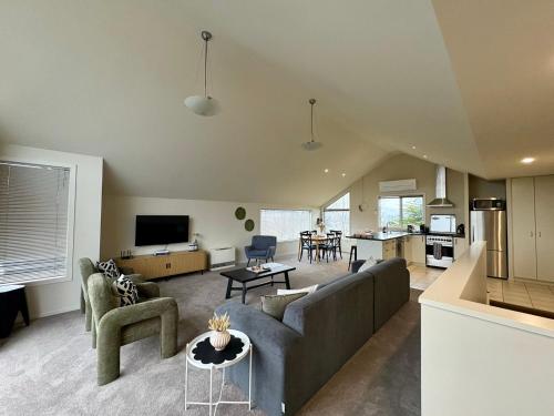 a living room with a couch and a table at Mountain Views on the Reserve in Wanaka