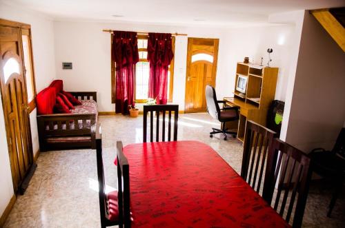 a living room with a red table and a kitchen at Departamentos Malargue in Malargüe