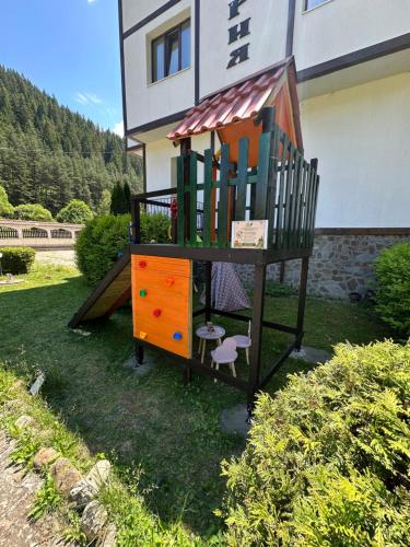 a play structure in the grass in front of a house at TRIIBRIA Guest house in Trigrad