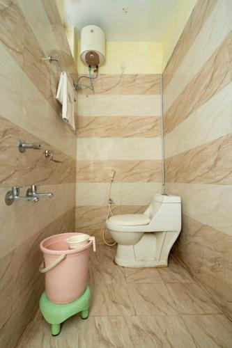 a bathroom with a toilet and a bucket at Meeraa Residency in Rāmeswaram