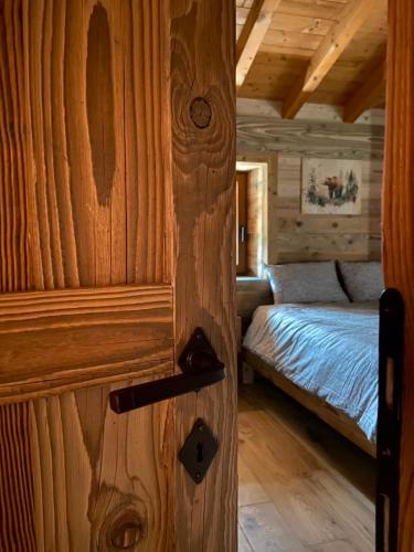 eine Tür zu einem Schlafzimmer mit einem Bett in einer Hütte in der Unterkunft Angel Chalet in Serina