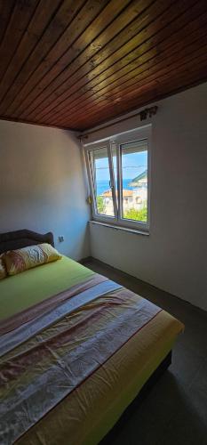 a bedroom with a bed and a window at Apartmani MAS in Dobra Voda