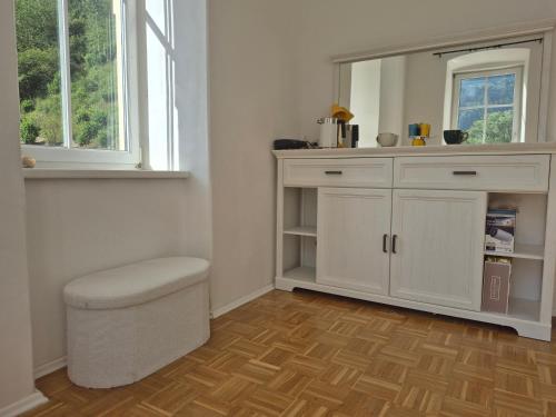a bathroom with a white cabinet with a stool and a mirror at Apartment Gletscher & Fluß in Penk