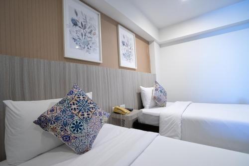 a hotel room with two beds and a window at The Spring Bangkok in Bangna