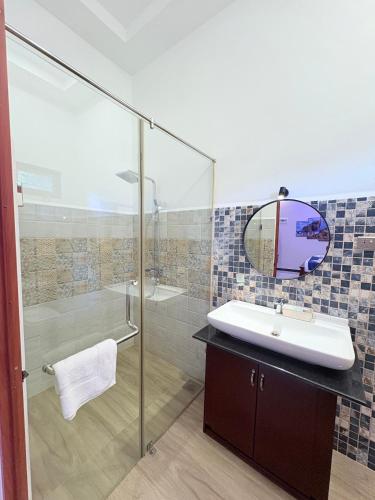a bathroom with a sink and a shower and a mirror at Infenta's Villa Hotel & restaurant in Pandattarippu
