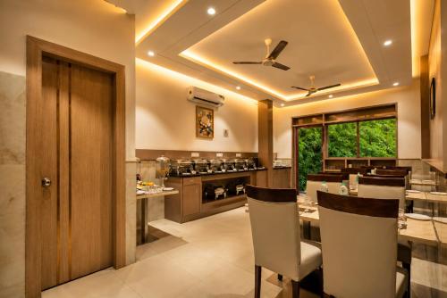 a kitchen with a dining room with a table and chairs at Dahabi Airport Hotel Era in New Delhi