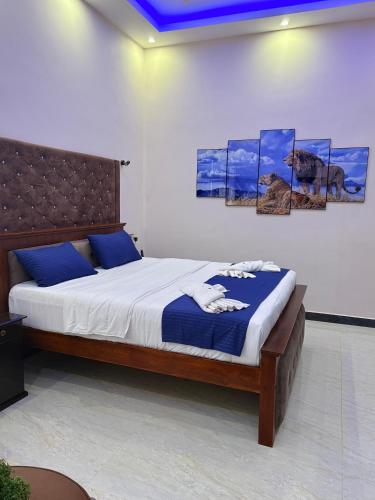 a bed in a room with paintings on the wall at Infenta's Villa Hotel & restaurant in Pandattarippu