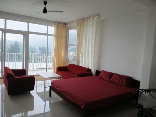 a living room with a bed and a couch and chairs at JIJIVISHA Homestay in Bhīm Tāl